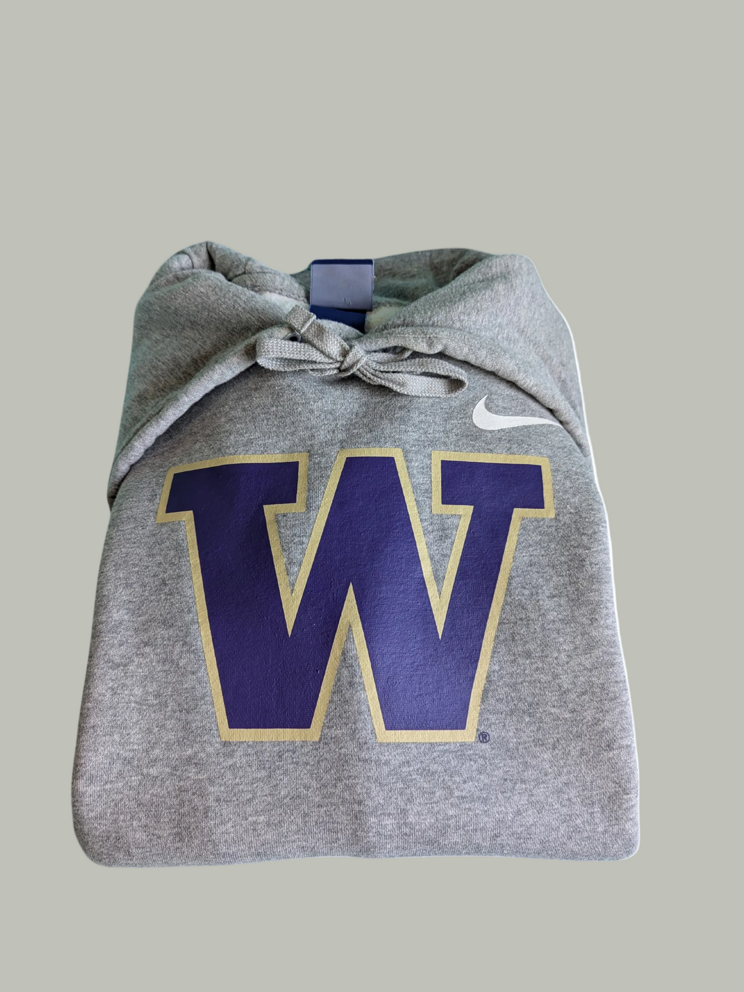 Close-up view of the purple and white embroidered varsity letter W graphic on the chest of a curated thrift Nike grey hoodie.