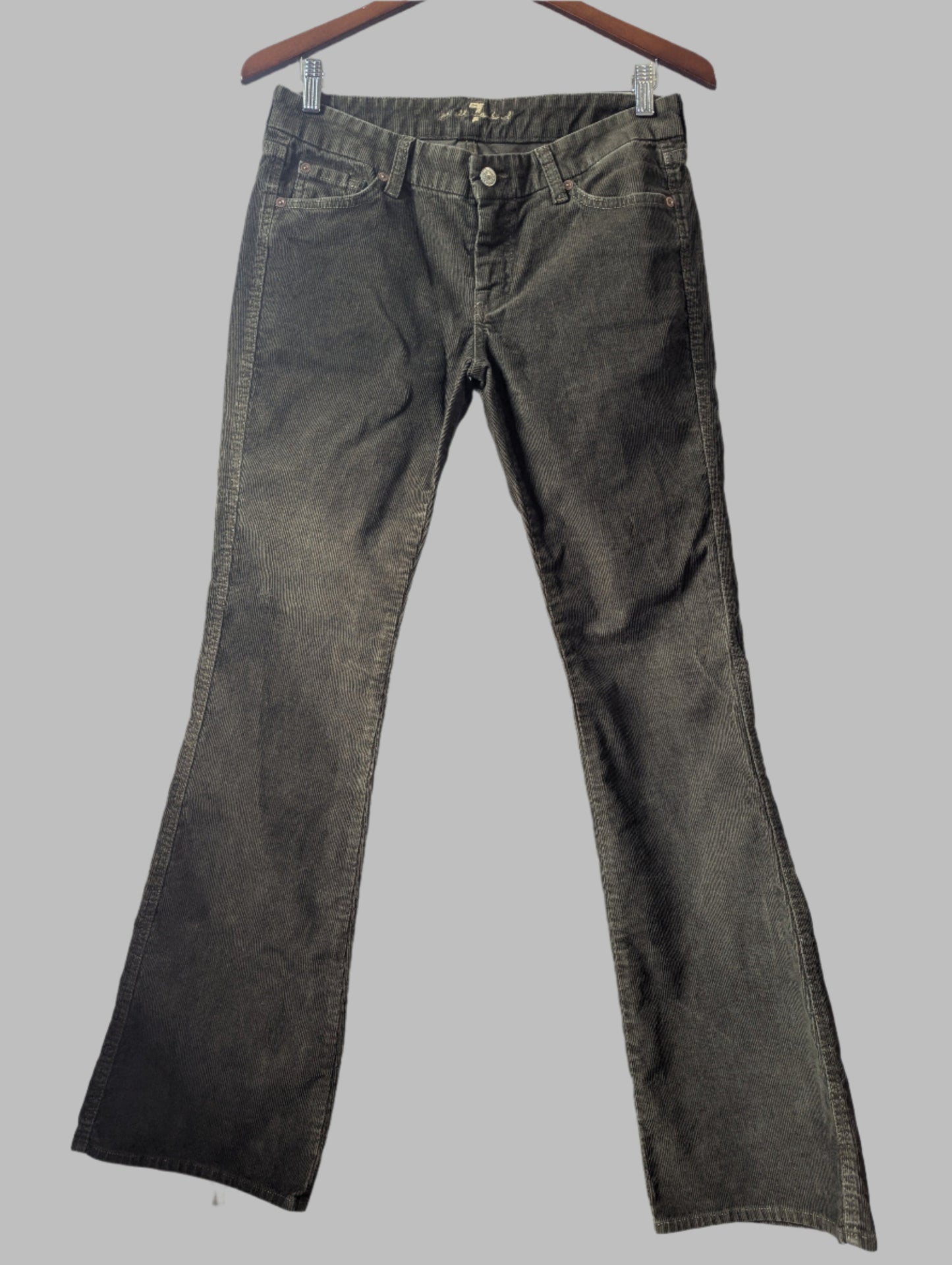 Front view of women's 7 For All Mankind khaki green bootcut corduroy pants hanging up.