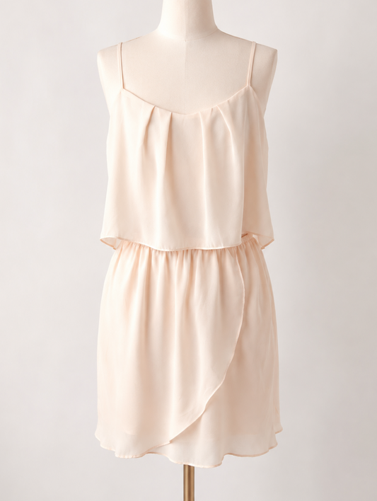 BCBG blush spaghetti strap layered mini dress with sheer cutout detail and hidden pockets displayed on mannequin