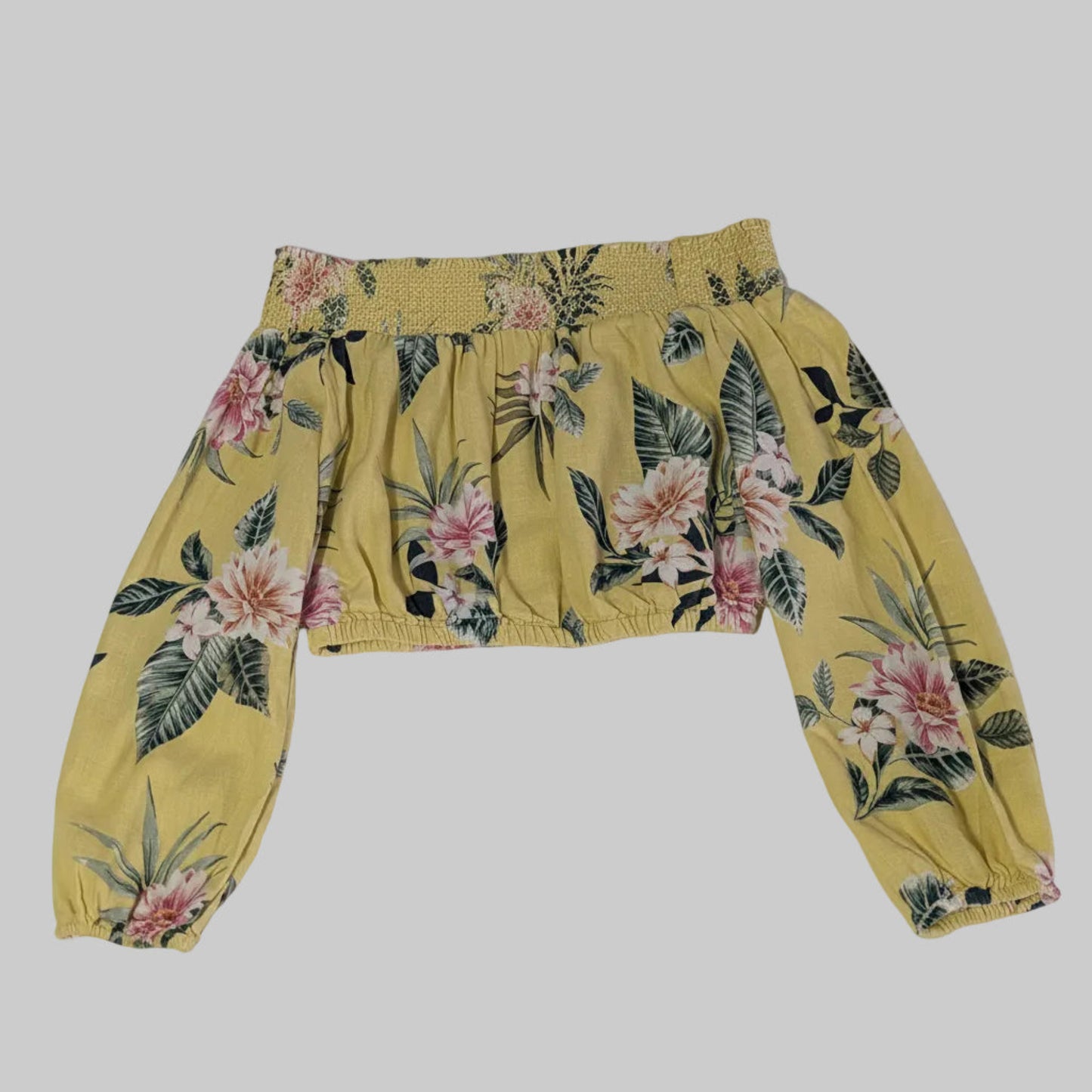 Flat lay of a vibrant yellow Guess off-the-shoulder linen crop top with a small multi-color floral boho print.