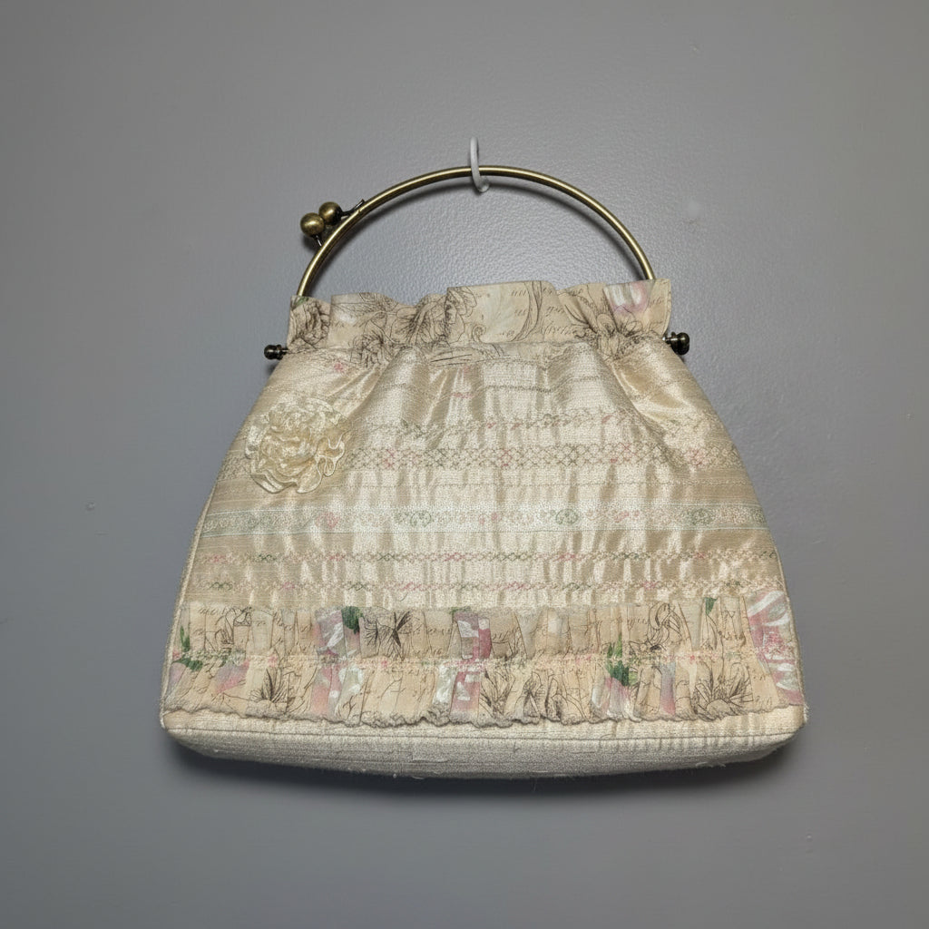 Vintage pastel brocade frame purse with a romantic scenic tapestry pattern and gold-tone metal kiss-lock handle.