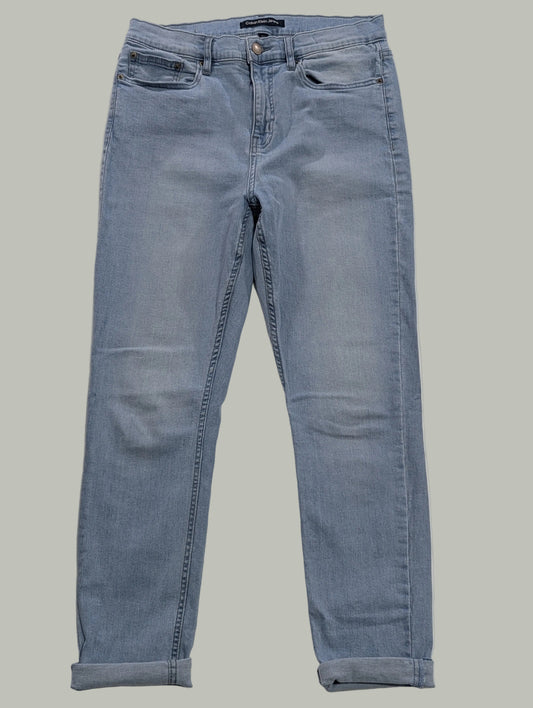 Front full-length view of light wash blue Calvin Klein super skinny jeans with folded cuffed hems, laying flat