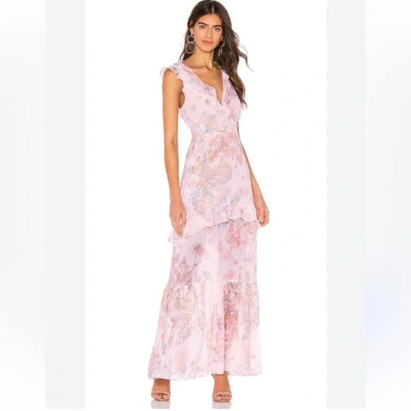 Full-length view of a model wearing a pink BCBGMAXAZRIA sleeveless maxi dress with a vibrant floral pattern and ruffled tiered skirt.