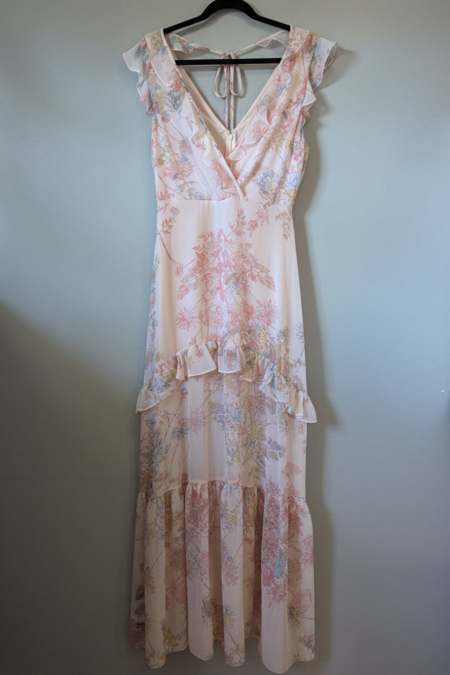 Full-length view of pink BCBGMAXAZRIA sleeveless maxi dress with a vibrant floral pattern and ruffled tiered skirt.