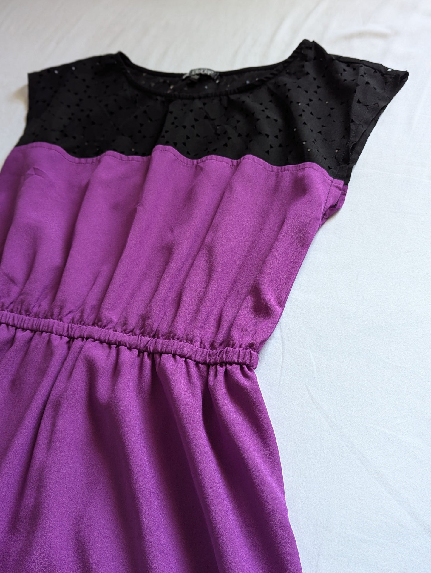 Close-up of the bodice on a purple Bebop mini dress, highlighting the gathered cinch waist and delicate eyelet fabric texture.