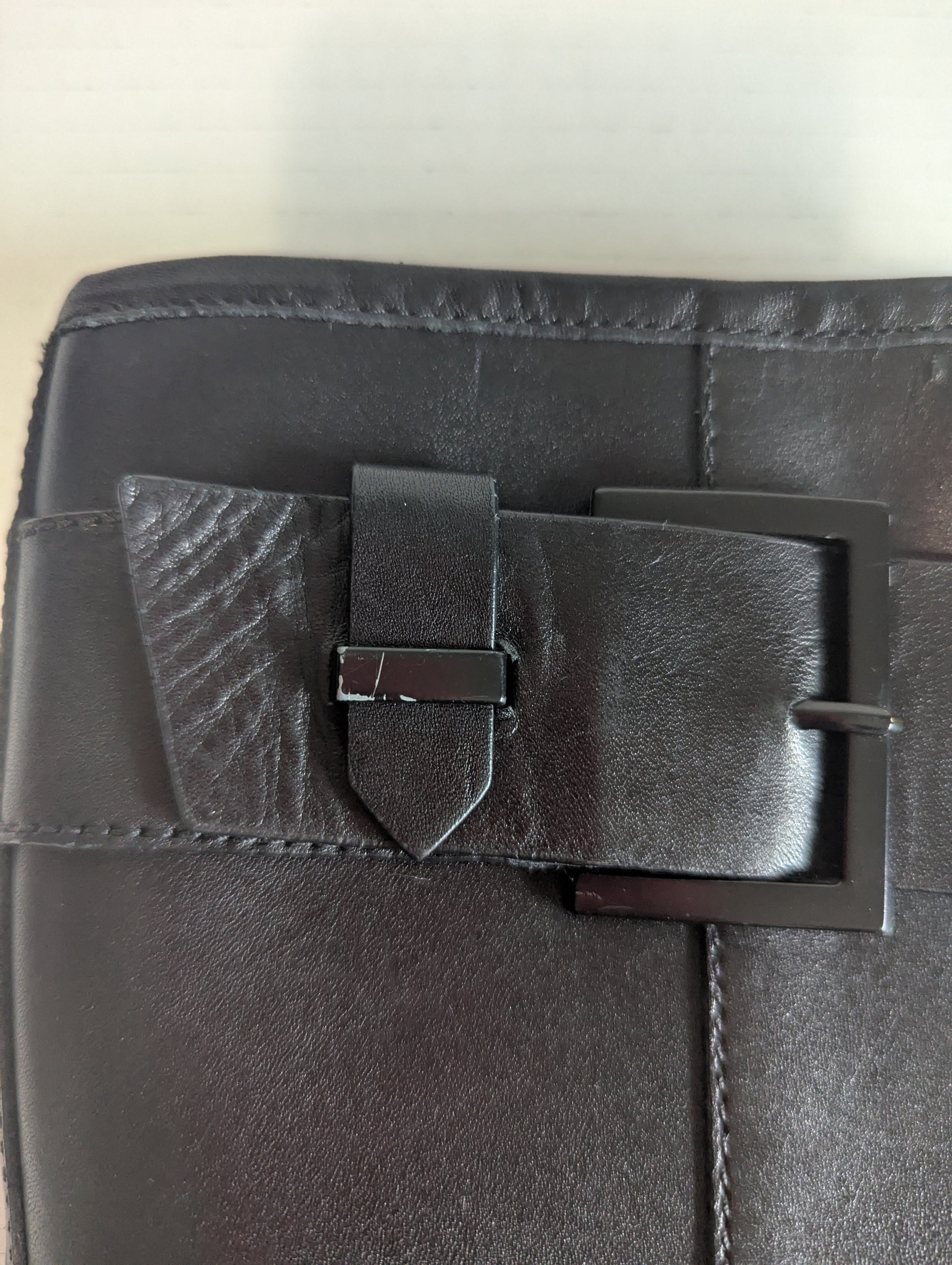 Close-up detail of the premium silver double buckle hardware accents on the ankle of the black leather boot