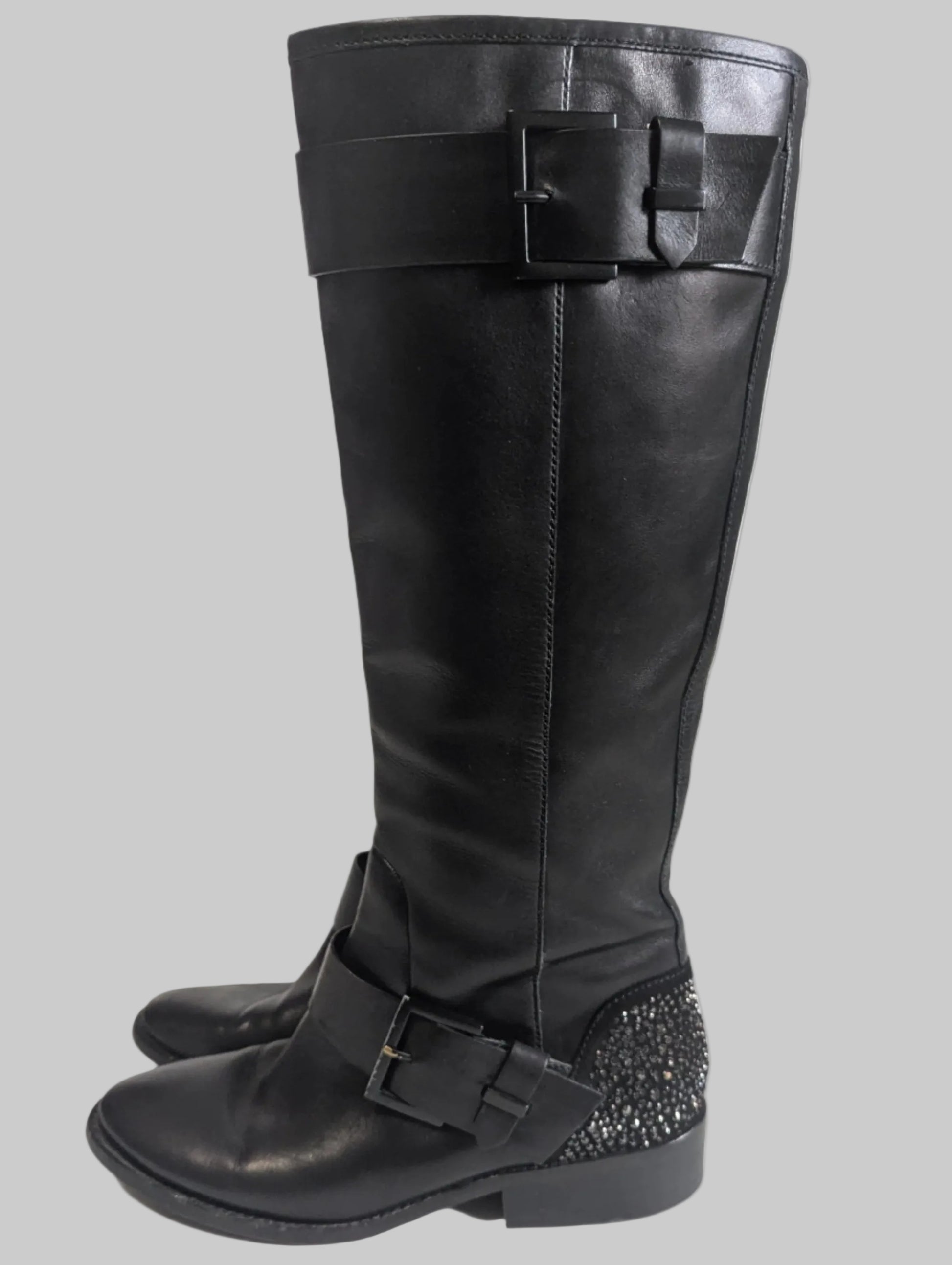 Side view of both black leather Brian Atwood boots showcasing the statement double buckle details.