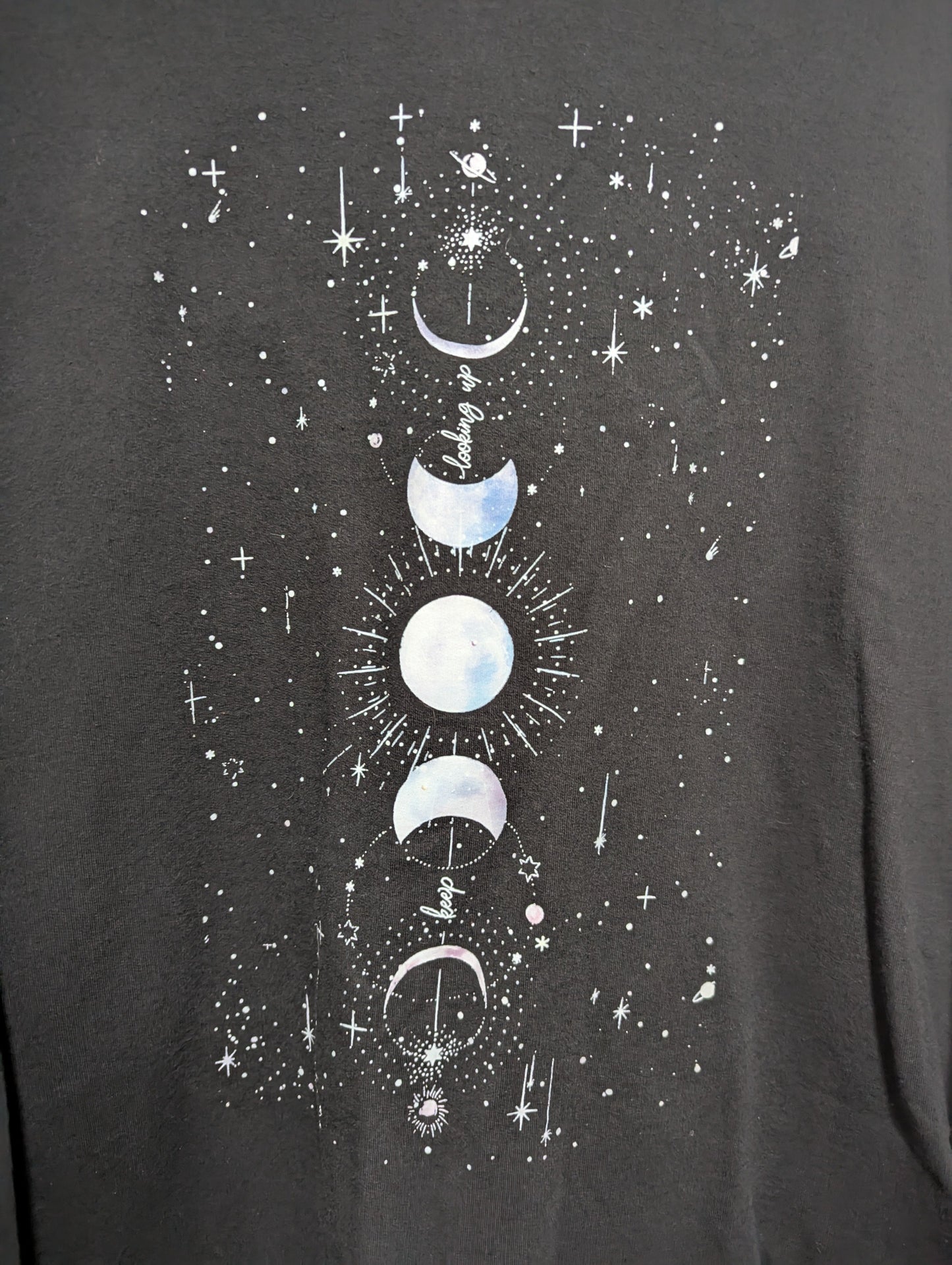 Close-up detail of the white graphic print illustrating the phases of the moon on the front of the black sweatshirt.