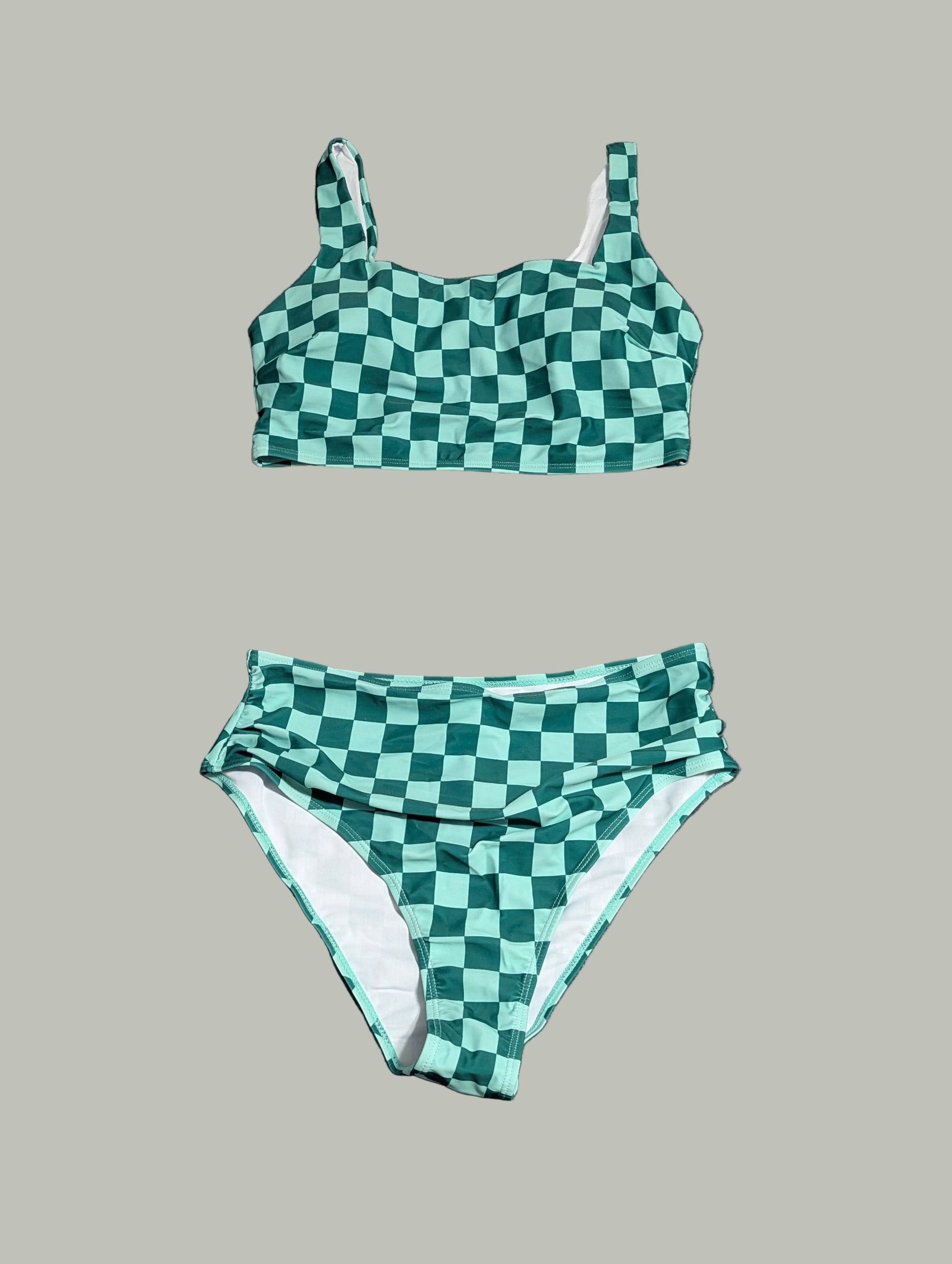 Front view of a curated thrift green and white checkered two-piece swimsuit with a cinched front detail on the bikini top, laid fla