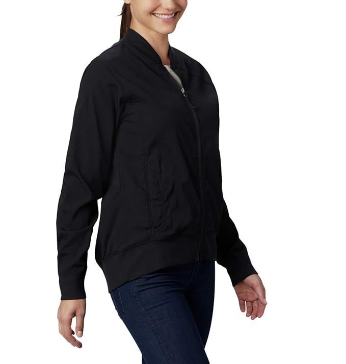 Model walking while wearing the lightweight black Columbia Bachy Butte long bomber jacket