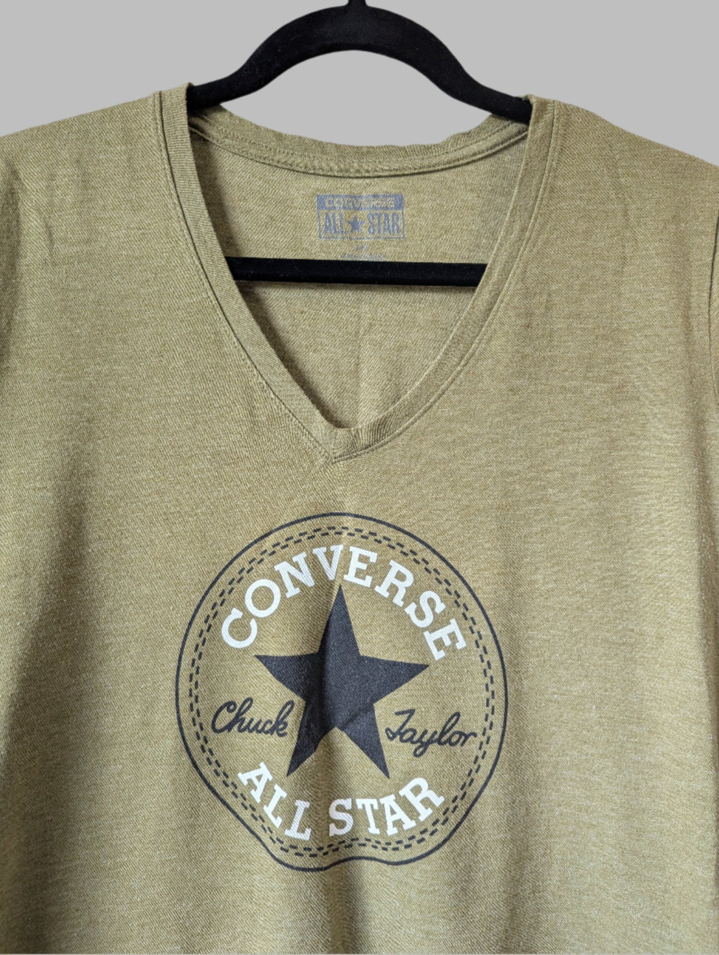Close-up detail of the inner Converse brand label and the ribbed V-neckline finish.