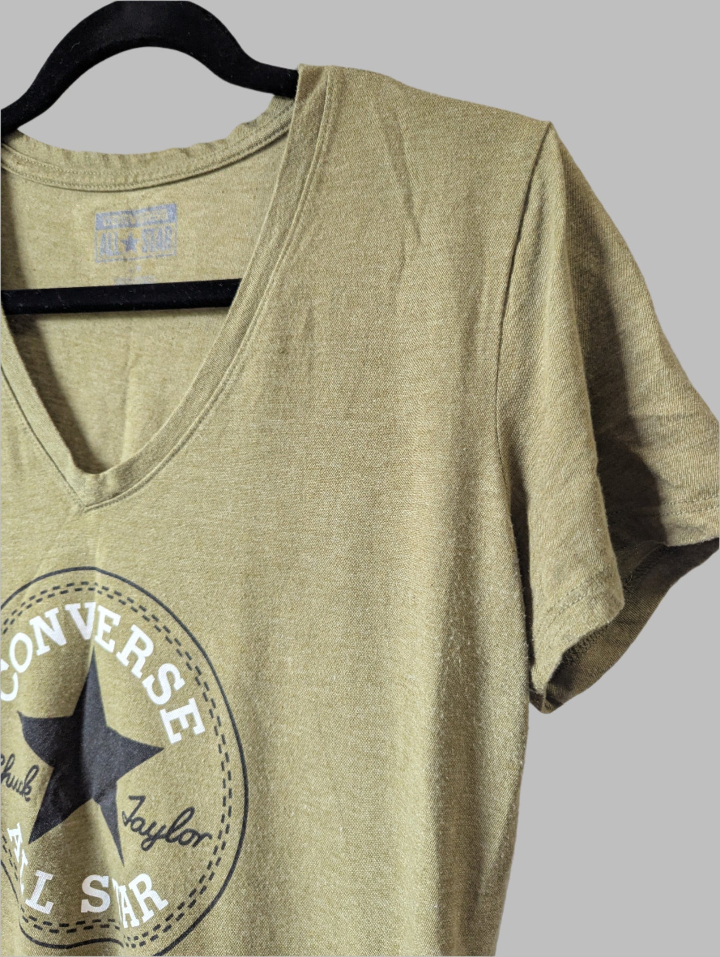 Close-up detail of the inner Converse brand label and the ribbed V-neckline finish