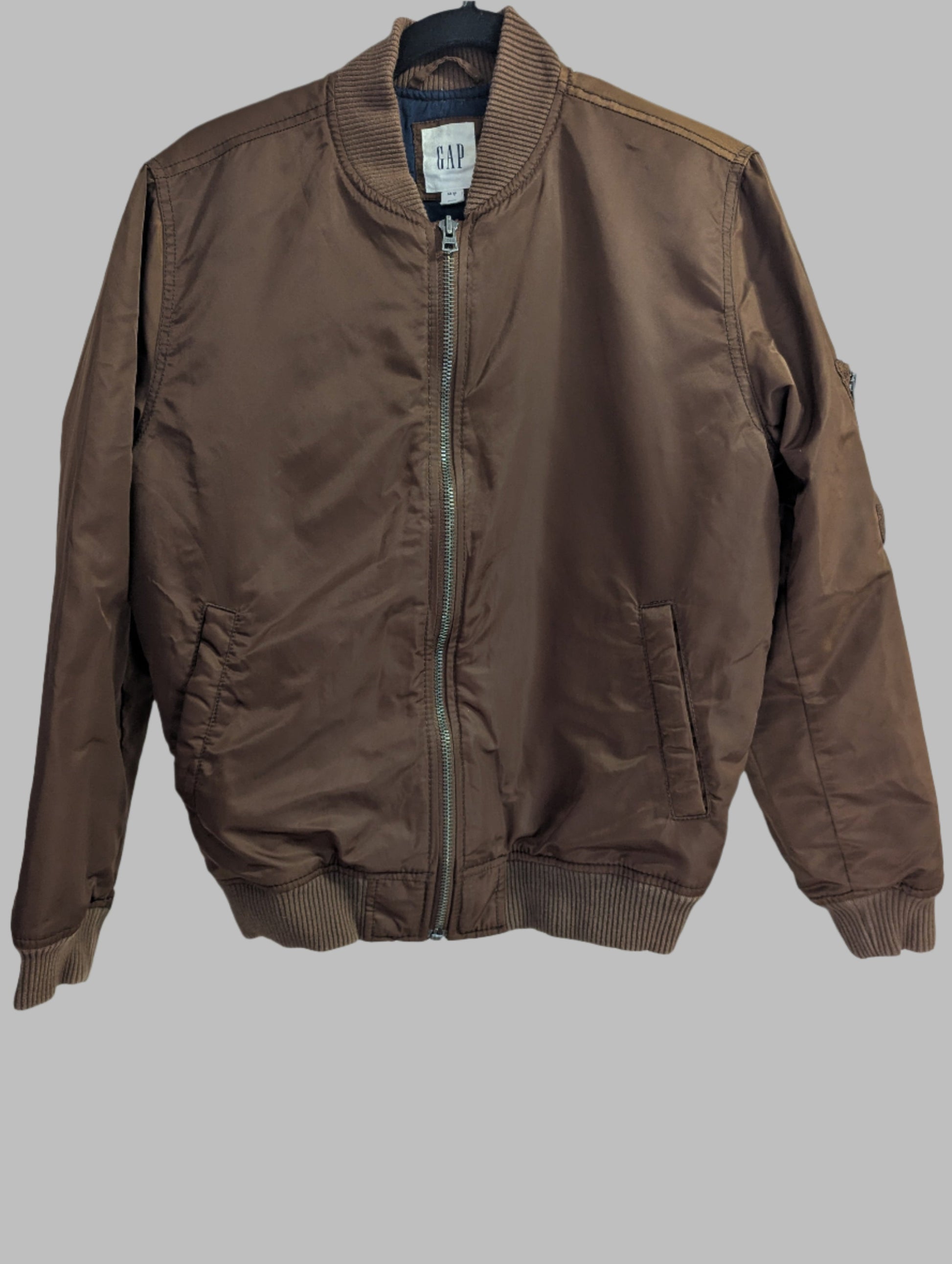 Front view of a Gap women's brown satin padded bomber jacket in size extra small hanging up