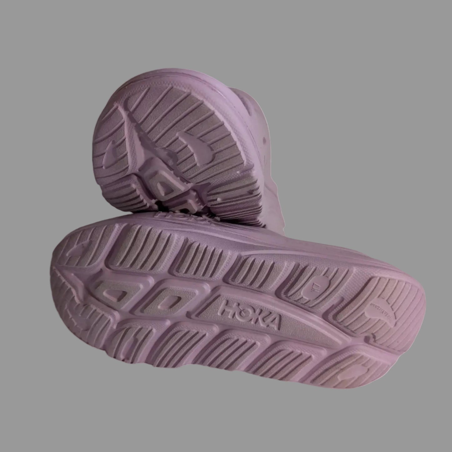Close-up view of the durable tread and supportive sole pattern on the purple Hoka Ora recovery sandals.