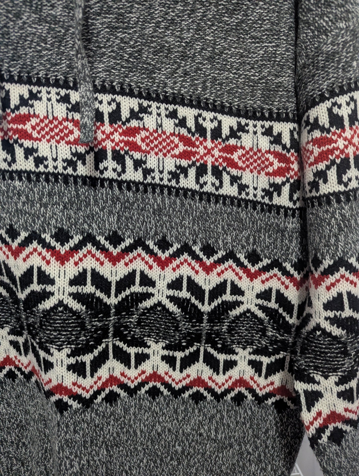 Close-up detail of the cozy acrylic-polyester blend knit texture and intricate snowflake pattern on the Kismet winter sweater.