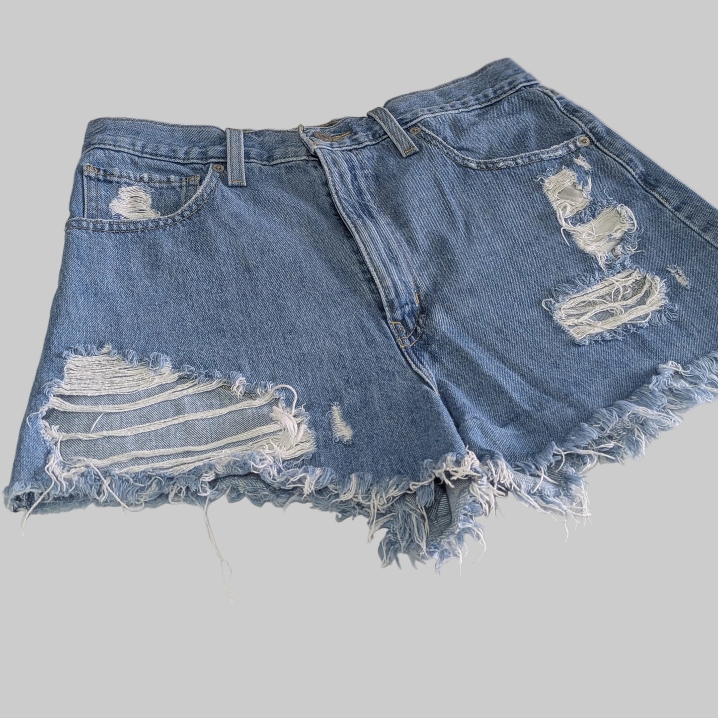 Front view of Levi's vintage 90s high waisted distressed denim mom shorts in a light wash blue.