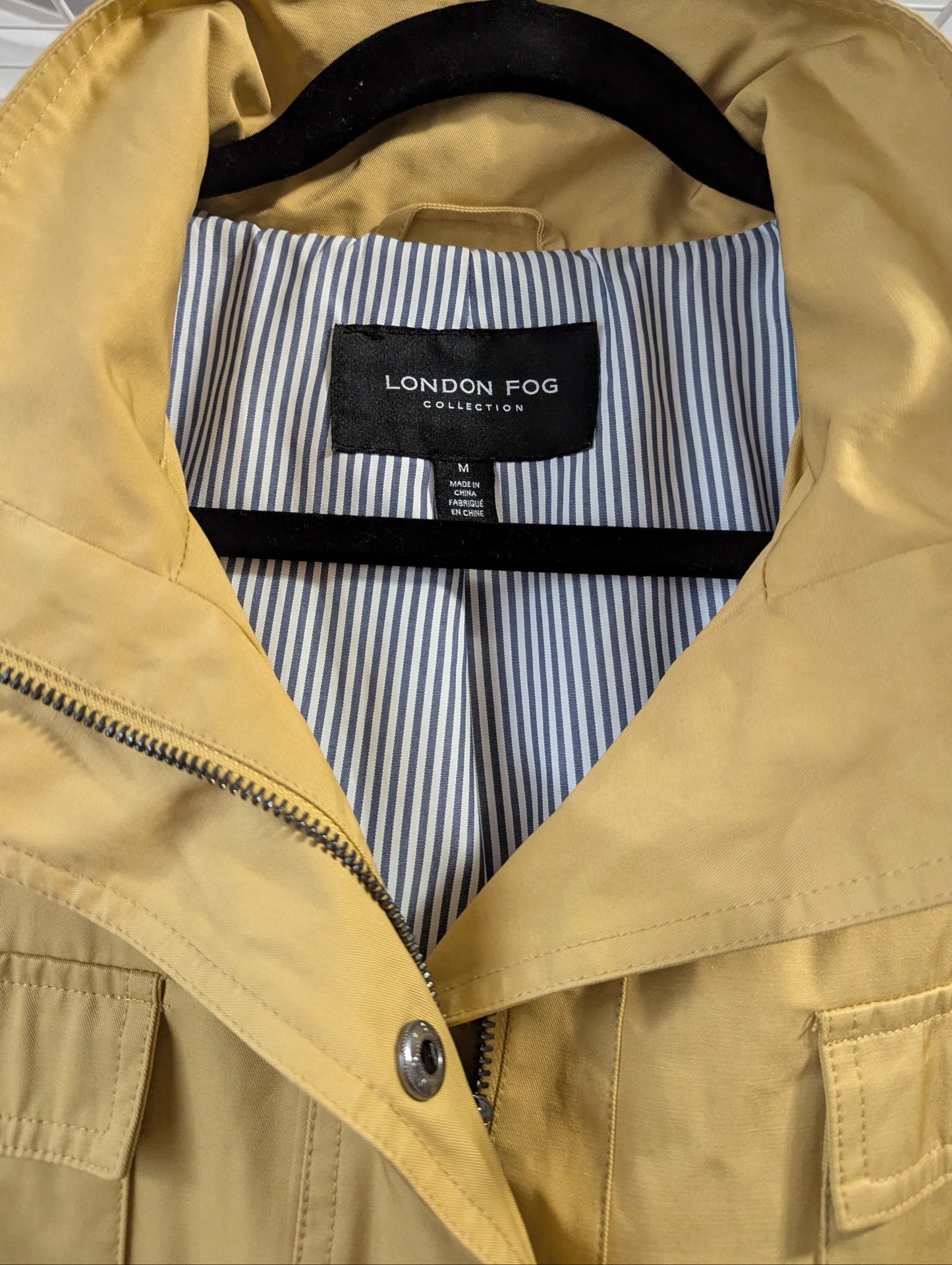 Close-up view of the collar and interior full polyester lining on the yellow London Fog trench coat.