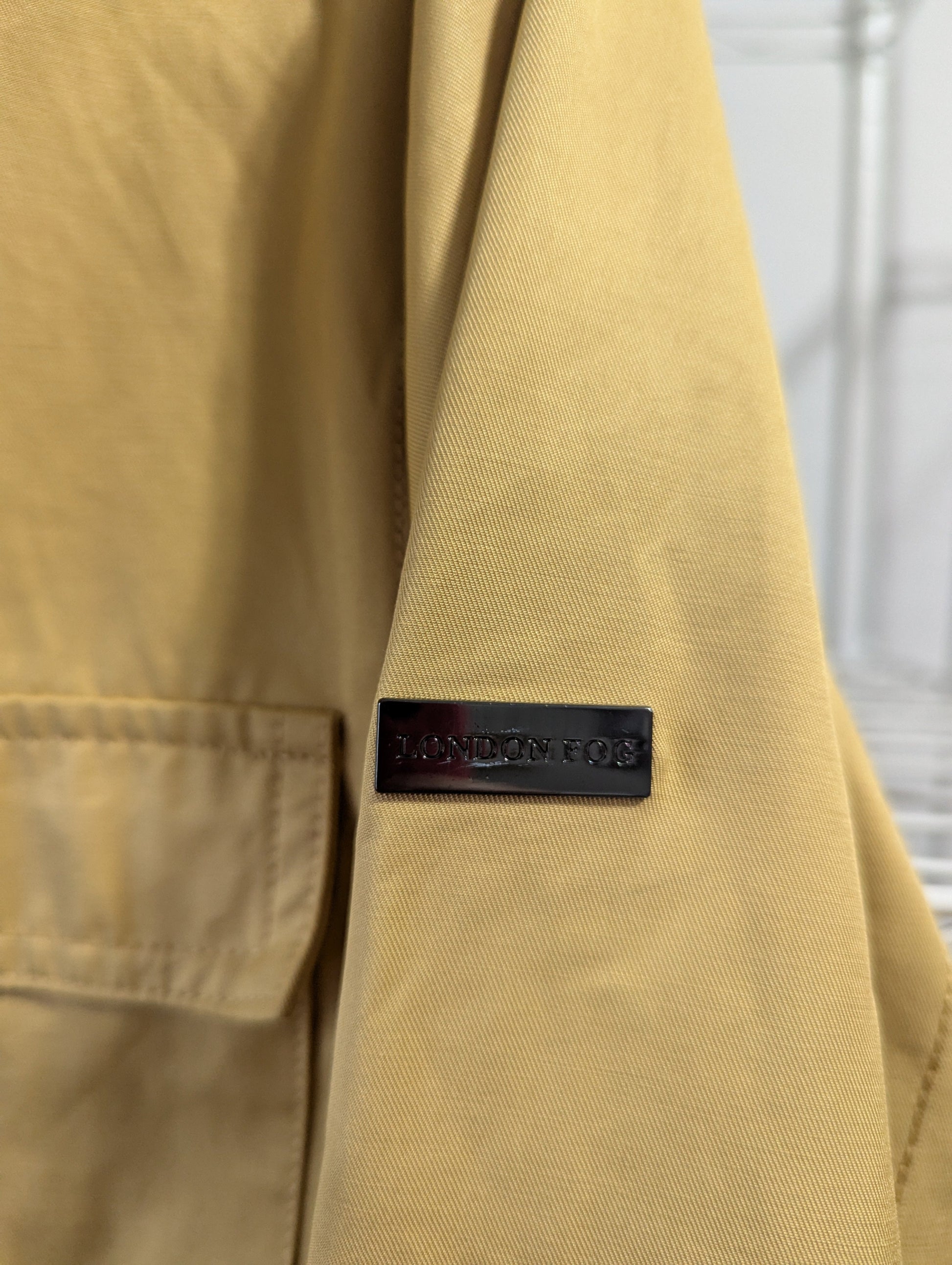 Close-up view of label detail on yellow London Fog utility coat