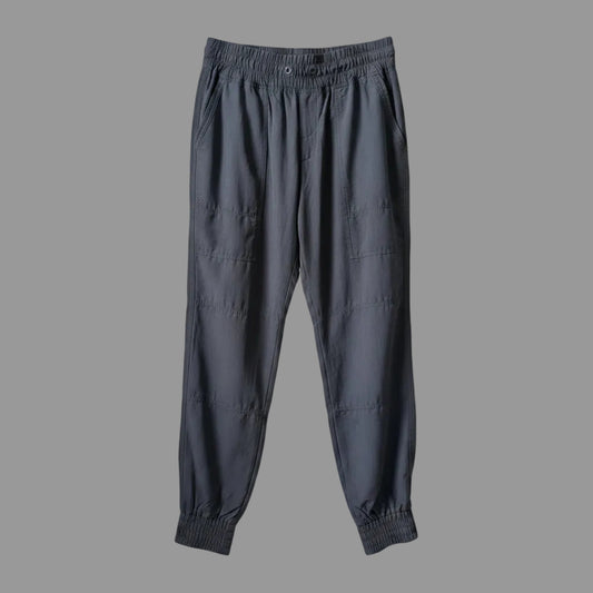 Front view of women's black MEC trek hiking pants with cinched ankles hanging on a hanger.