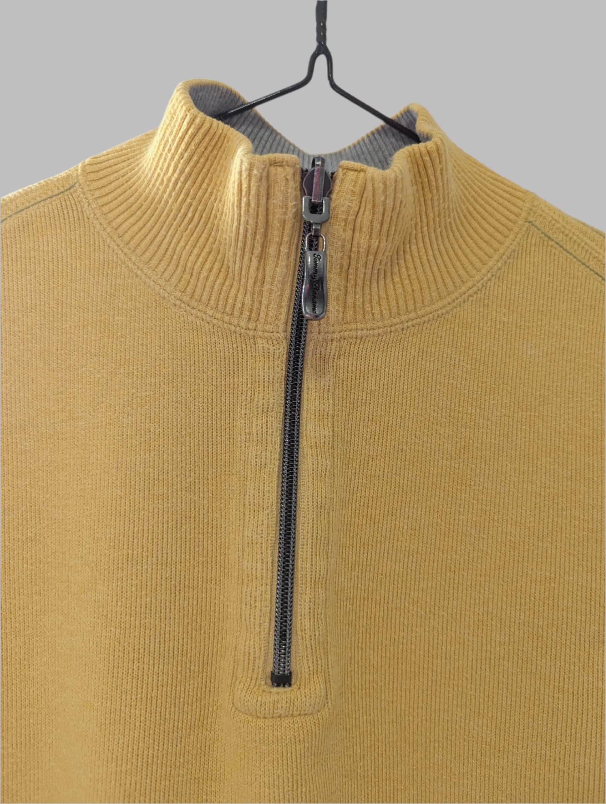 Front view of a men's yellow Tommy Bahama quarter-zip mock neck sweater hanging on a hanger