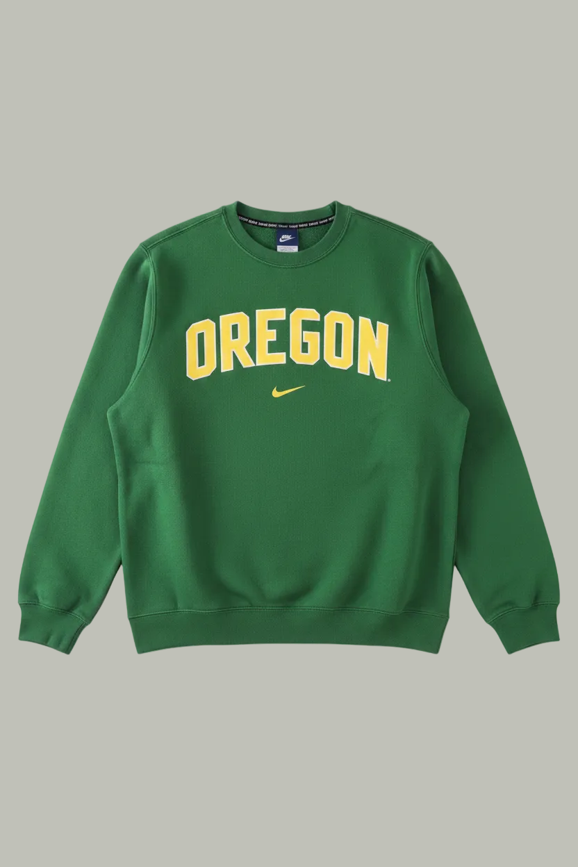Front lay flat view of a green Nike Oregon Ducks crewneck sweatshirt with yellow and white block lettering 