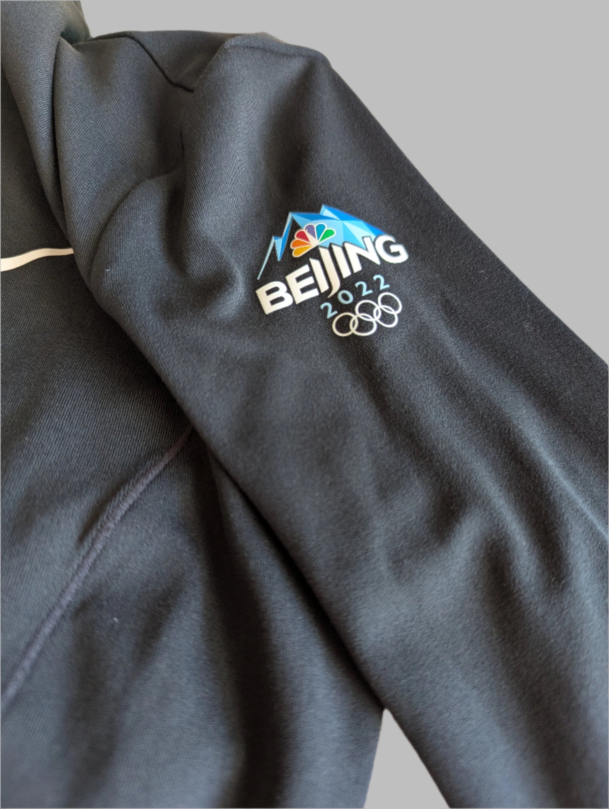 Sleeve detail of beijing 2022 olypics on a black Nike Yoga Dri-Fit full zip athletic jacket 