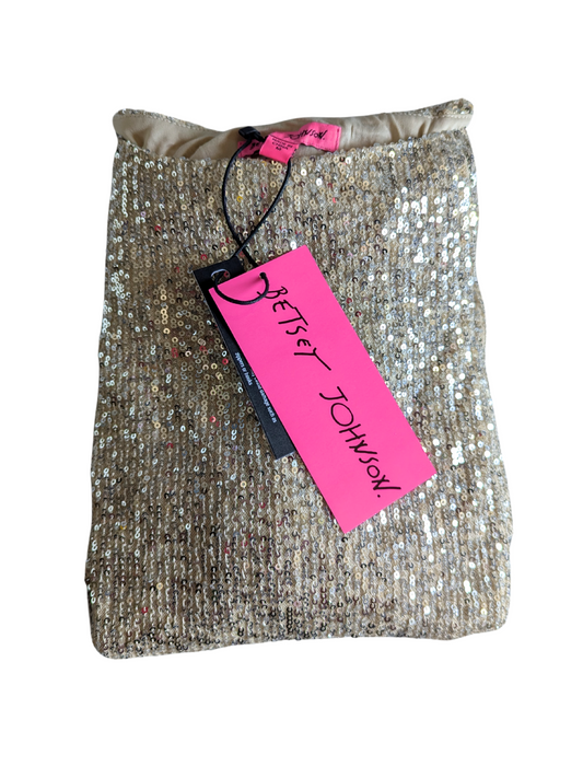 A Betsey Johnson Gold Stretch Sequin Relaxed Fit Mini Dress (Size Medium) from Feather & Fable Thrift Co. is displayed folded with tags, including a pink tag, on a white background. The mini dress features sparkling gold sequins for a glamorous look.