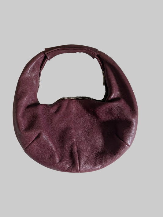 Front view of a maroon genuine leather P'elle half-moon handbag with a shoulder strap.