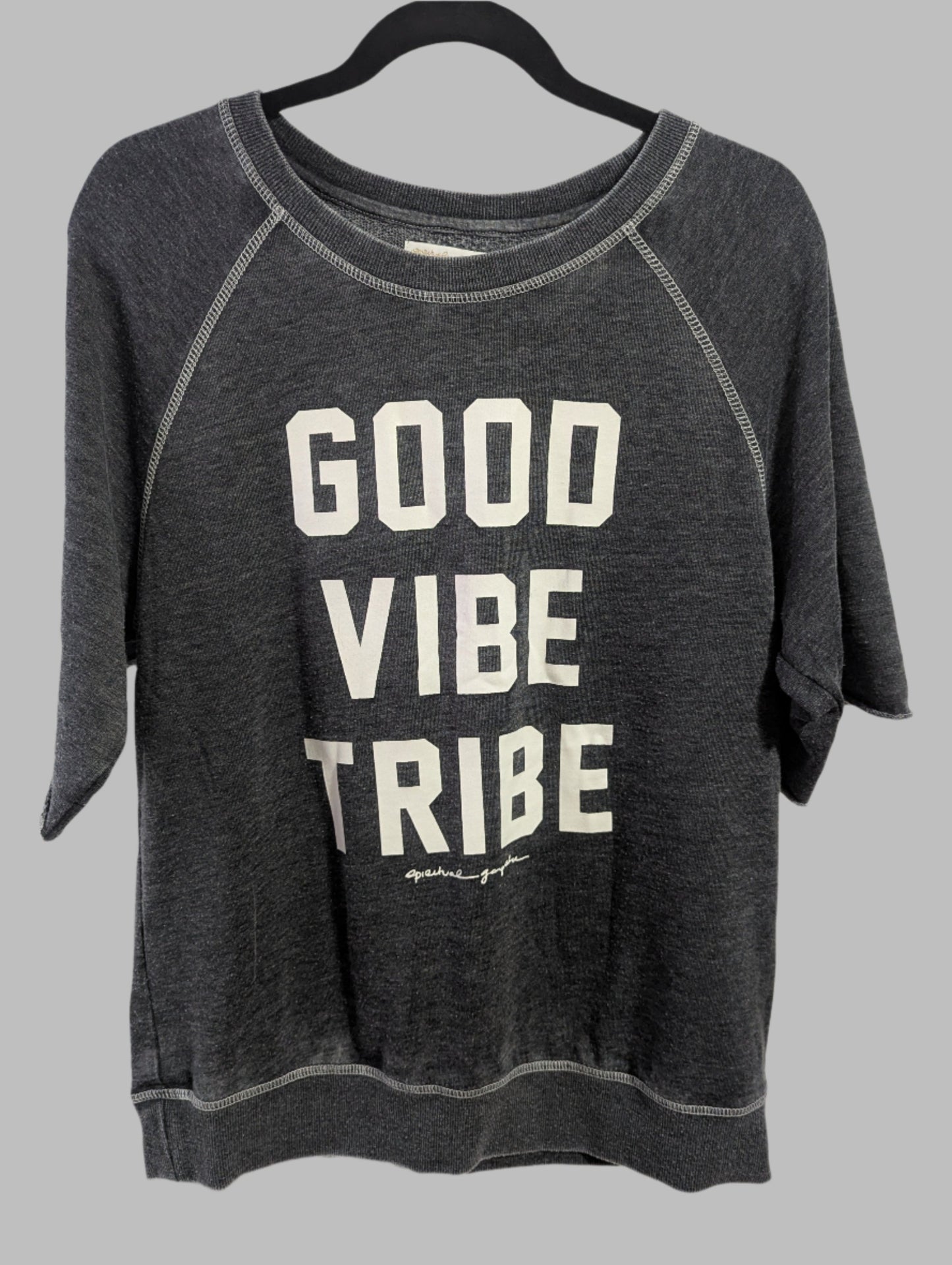 Front view of a grey Spiritual Gangster crew neck sweatshirt with Good Vibe Tribe text hanging on a hanger.