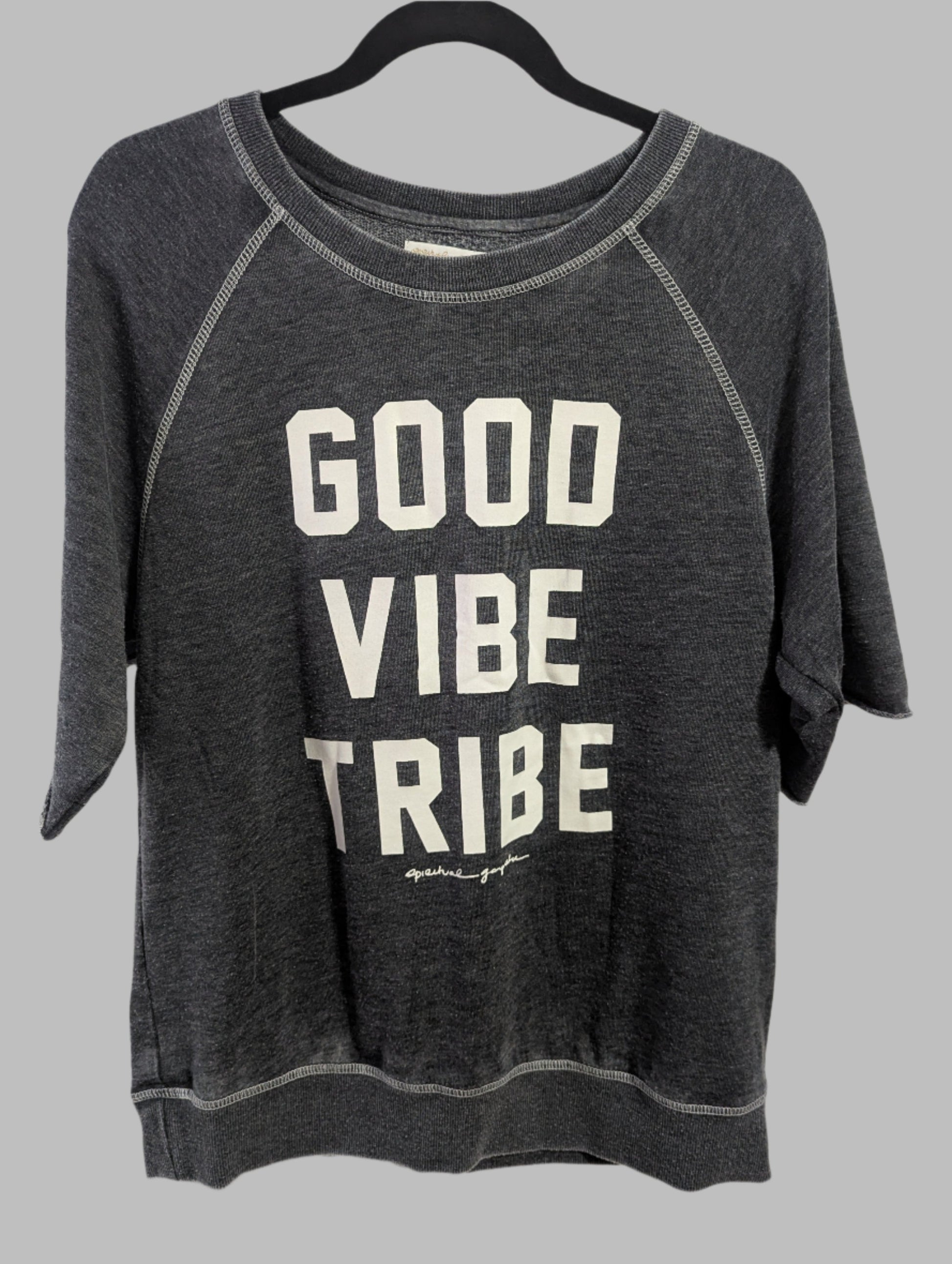 Front view of a grey Spiritual Gangster crew neck sweatshirt with Good Vibe Tribe text hanging on a hanger.