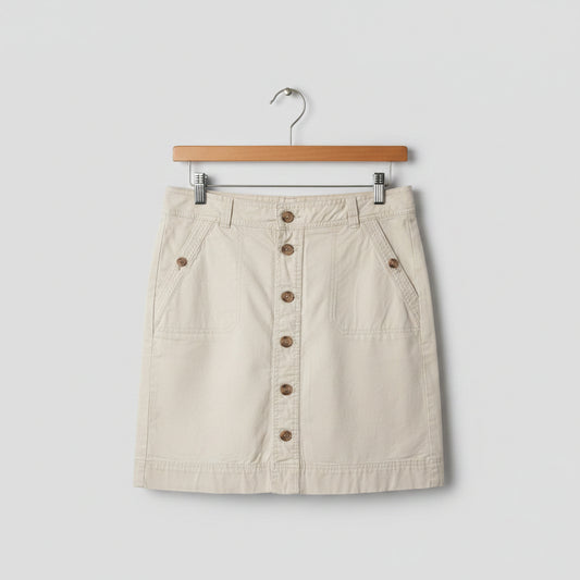 Front view of a khaki beige Tommy Hilfiger A-line midi skirt with a front button-down closure and utility pockets hanging on a wooden hanger