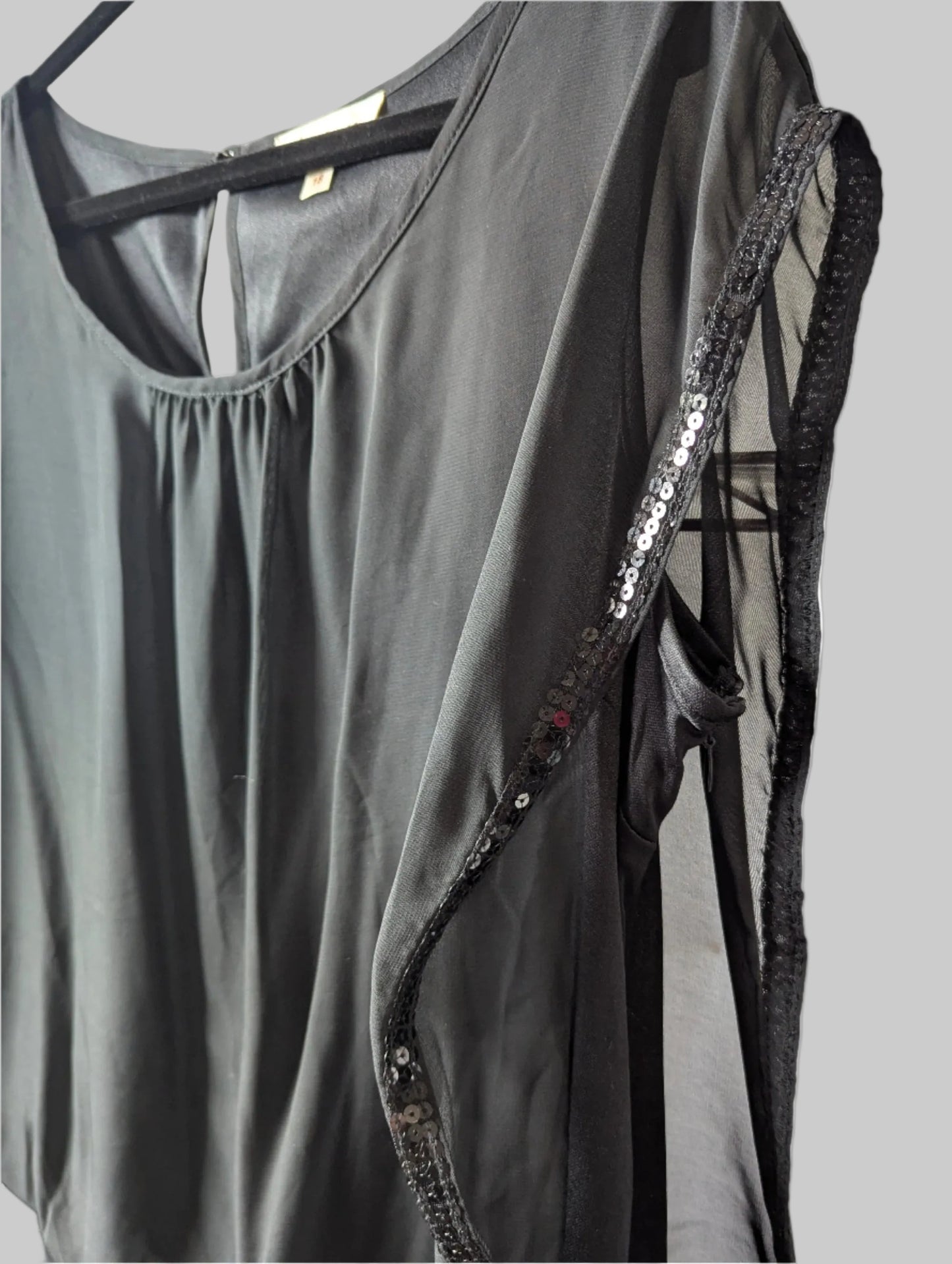 Close-up detail of the glamorous black sheer sequin fabric overlay.