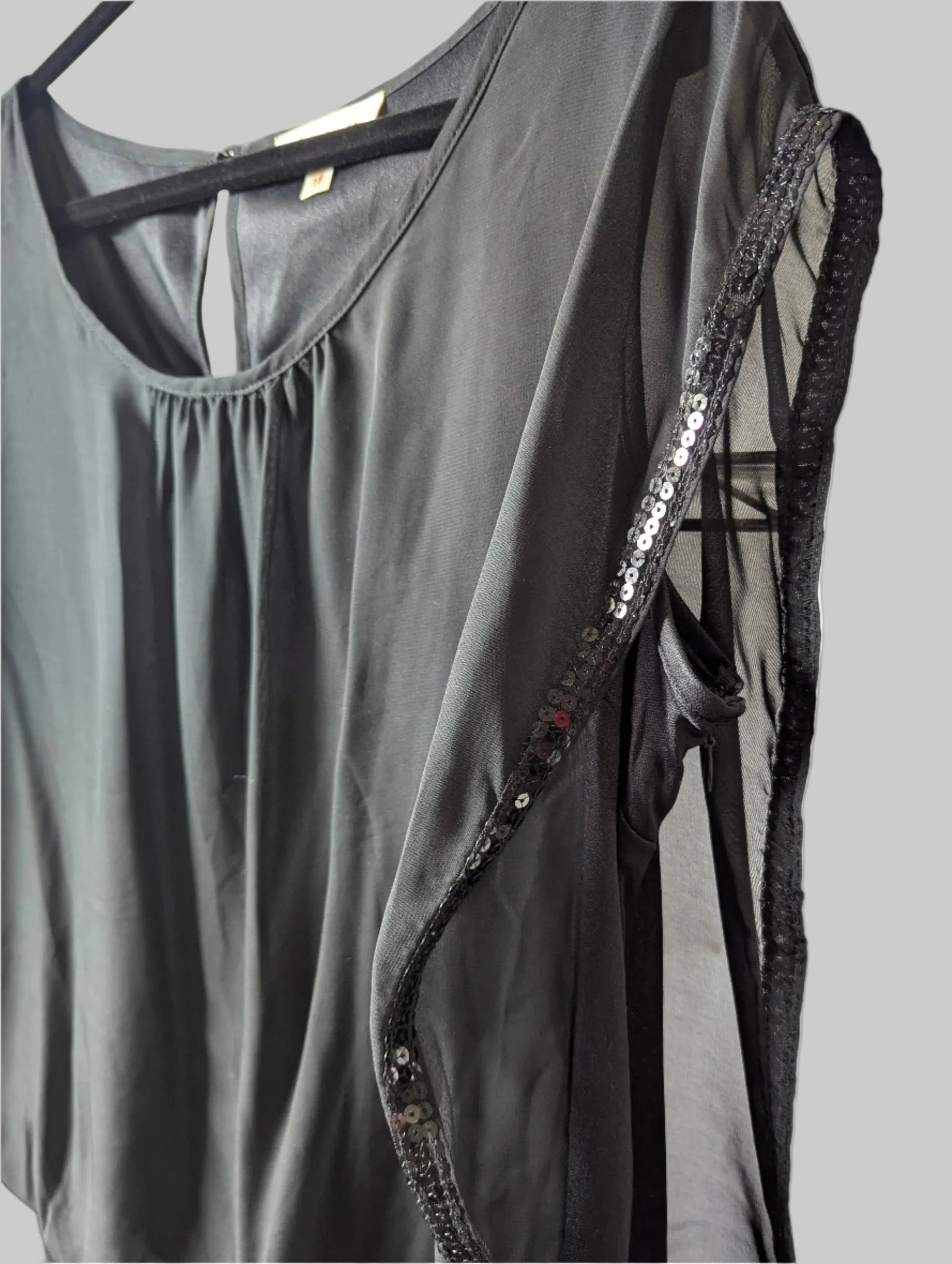 Close-up detail of the glamorous black sheer sequin fabric overlay.