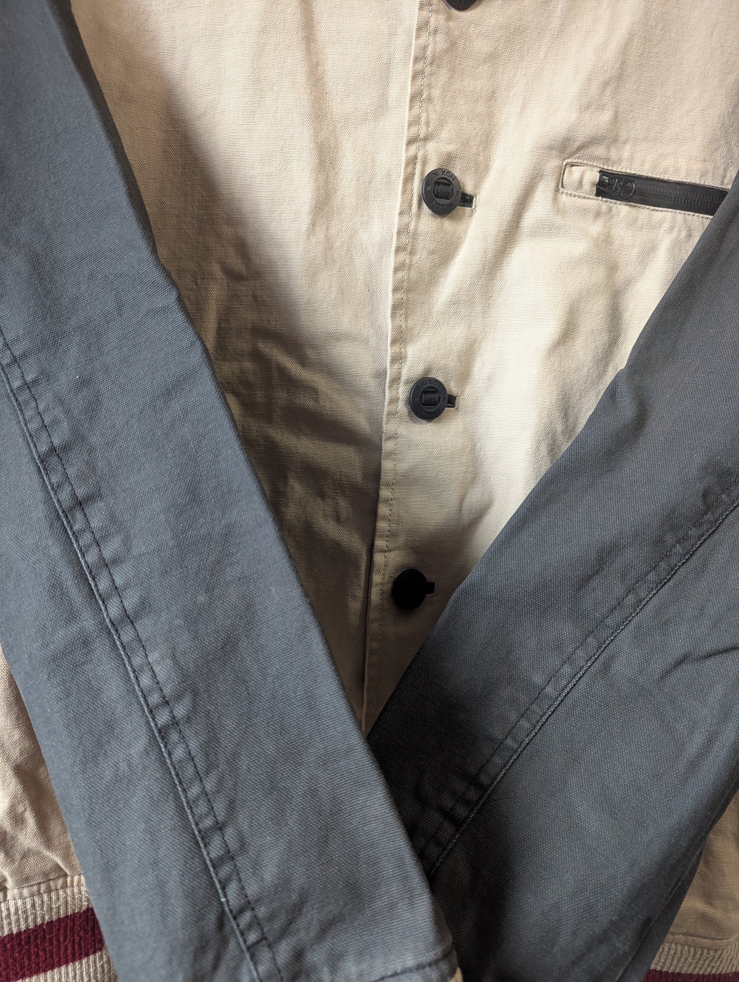 Macro close-up view showing the minor authentic wear and slight vintage discoloration on the fabric of the well-loved jacket.