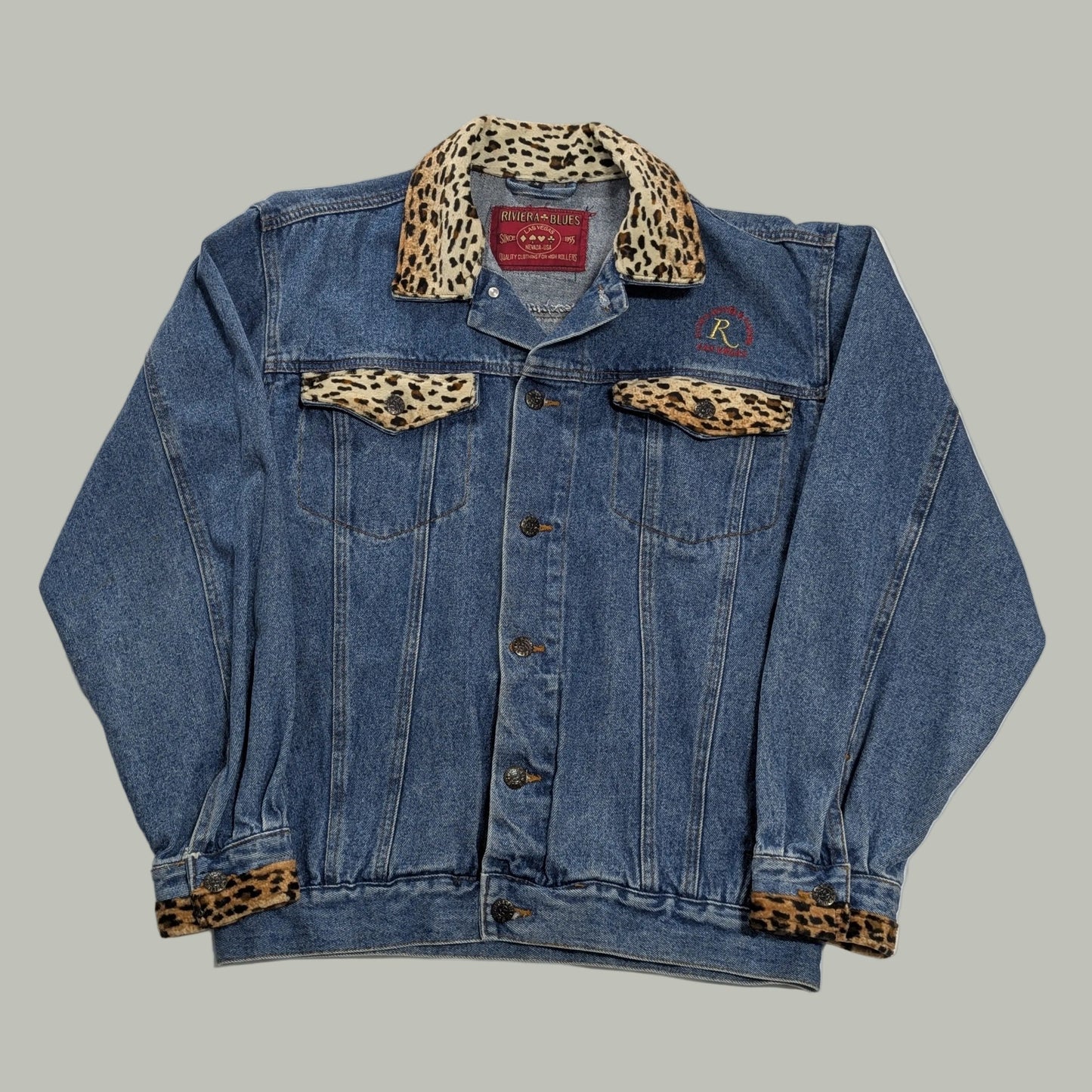 Front full-length view of a vintage blue denim trucker jacket with custom Las Vegas Riviera Hotel embroidery, channeling a 90s streetwear aesthetic