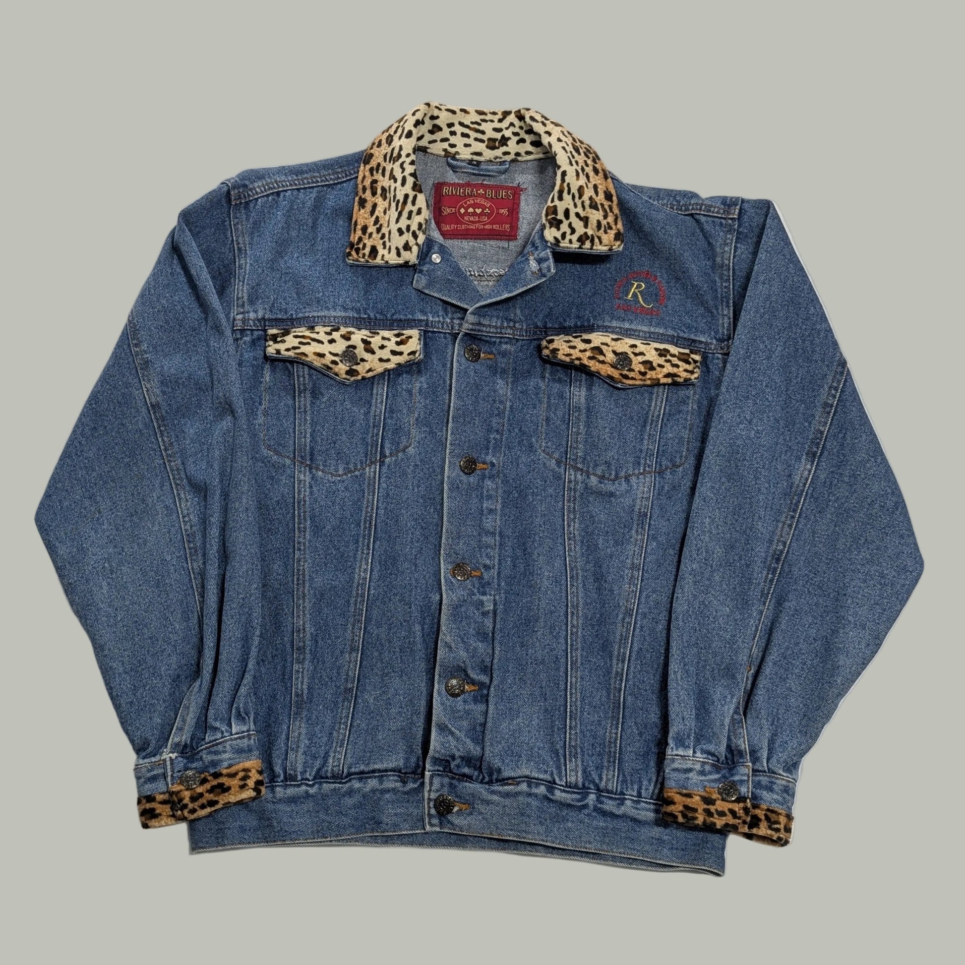 Front full-length view of a vintage blue denim trucker jacket with custom Las Vegas Riviera Hotel embroidery, channeling a 90s streetwear aesthetic