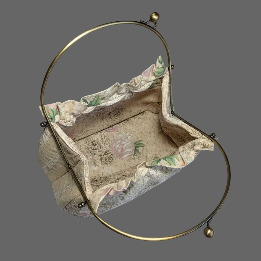 Vintage pastel brocade frame purse with a romantic scenic tapestry pattern and gold-tone metal kiss-lock handle.