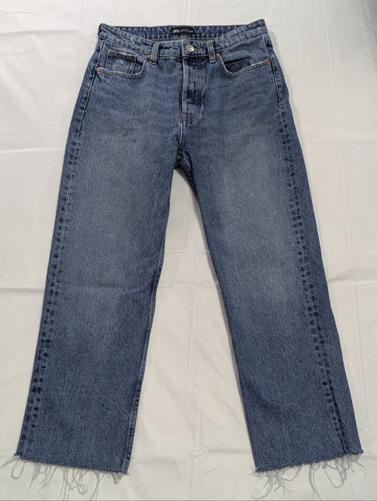 Full-length front view of mid-wash blue Zara high-rise cropped denim jeans with raw frayed hems, displayed flat.
